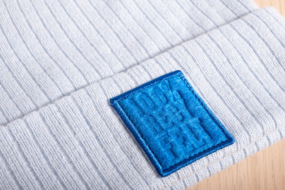 Patch i återvunnen filt med präglad logga
